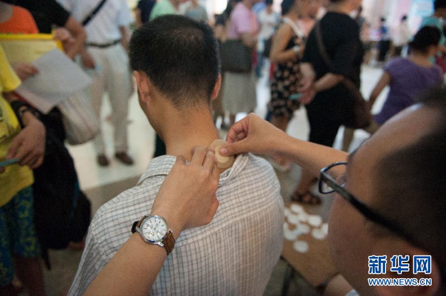 A doctor applies "hot summer days plaster medicine" to a man at the Guangdong Provincial Traditional Chinese Medical Hospital July 3, 2013.(Photo: Mao Siqian/Xinhua)