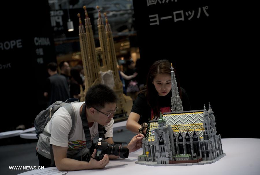 Visitors view exhibits at the preview of a LEGO exhibition at the Cityplaza in Hong Kong, south China, July 4, 2013. Featuring 40 world heritage sites with over half a million LEGO bricks, the exhibition will be held from July 5 to July 31. (Xinhua/Lui Siu Wai)