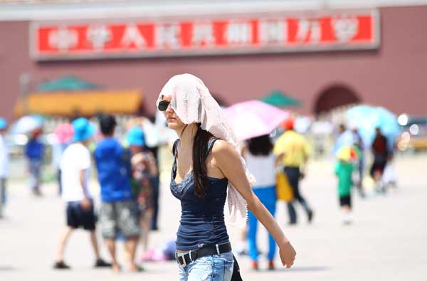 Tourists feel the heat in Tian'anmen Square, Beijing, on Wednesday when a temperature of 36 C was recorded at noon, a record-high since the start of summer, according to the city’s weather forecasters. (China Daliy  / Zou Hong)