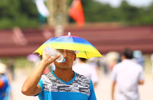 Tourists feel the heat in Tian'anmen Square, Beijing, on Wednesday when a temperature of 36 C was recorded at noon, a record-high since the start of summer, according to the city’s weather forecasters. (China Daliy  / Zou Hong)