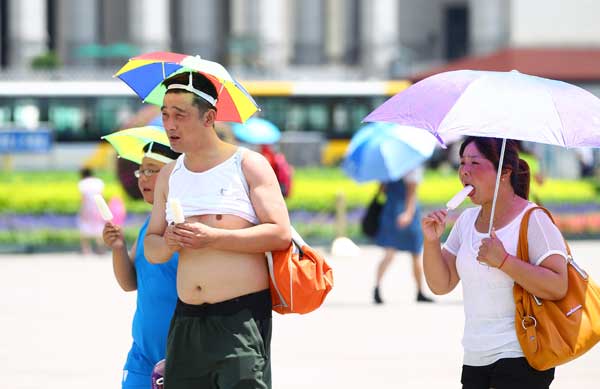 Tourists feel the heat in Tian'anmen Square, Beijing, on Wednesday when a temperature of 36 C was recorded at noon, a record-high since the start of summer, according to the city’s weather forecasters. (China Daliy  / Zou Hong)