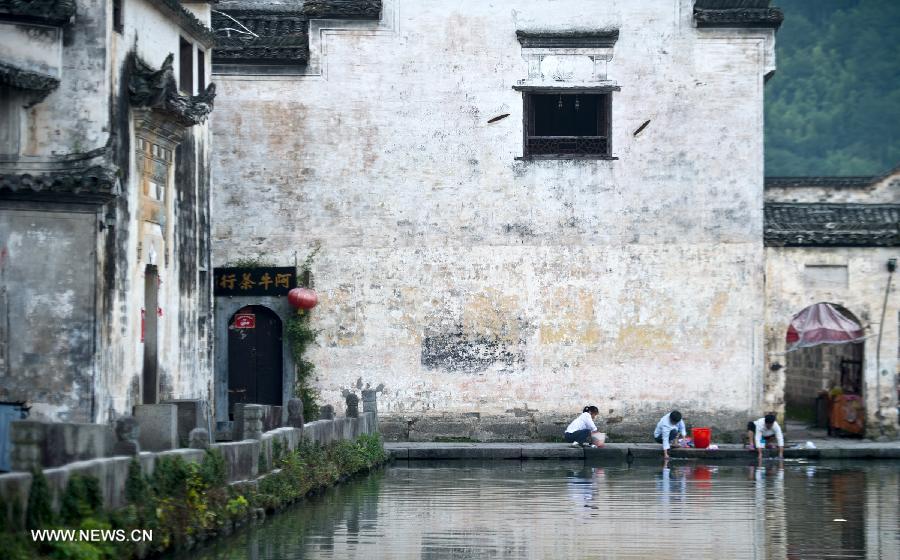Local residents do laundry at the Yuezhao, or Moon Pool, at Hongcun, an ancient village founded in 1131 in Huangshan City, east China's Anhui Province, July 3, 2013. Listed as a world cultural heritage site, the village preserved to a remarkable extent the surviving examples of Anhui-style architecture and traditional lifestyle. (Xinhua/Guo Chen) 