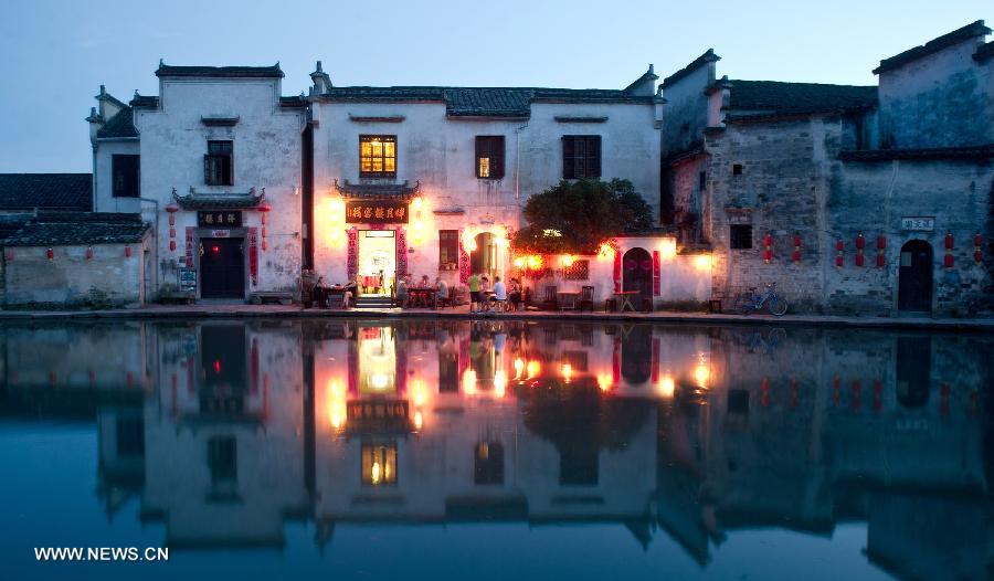 Tourists dine at a restaurant by the side of the Yuezhao, or Moon Pool, at Hongcun, an ancient village founded in 1131 in Huangshan City, east China's Anhui Province, July 2, 2013. Listed as a world cultural heritage site, the village preserved to a remarkable extent the surviving examples of Anhui-style architecture and traditional lifestyle. (Xinhua/Guo Chen)