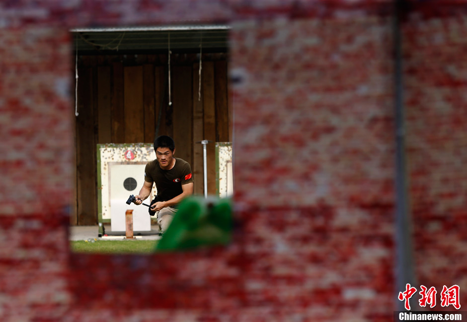 Trainees receive the tactical shooting training during a VIP security training course in Lianyungang, east China's Jiangsu province, June 30, 2013. (Chinanews/Liu Guanguan)