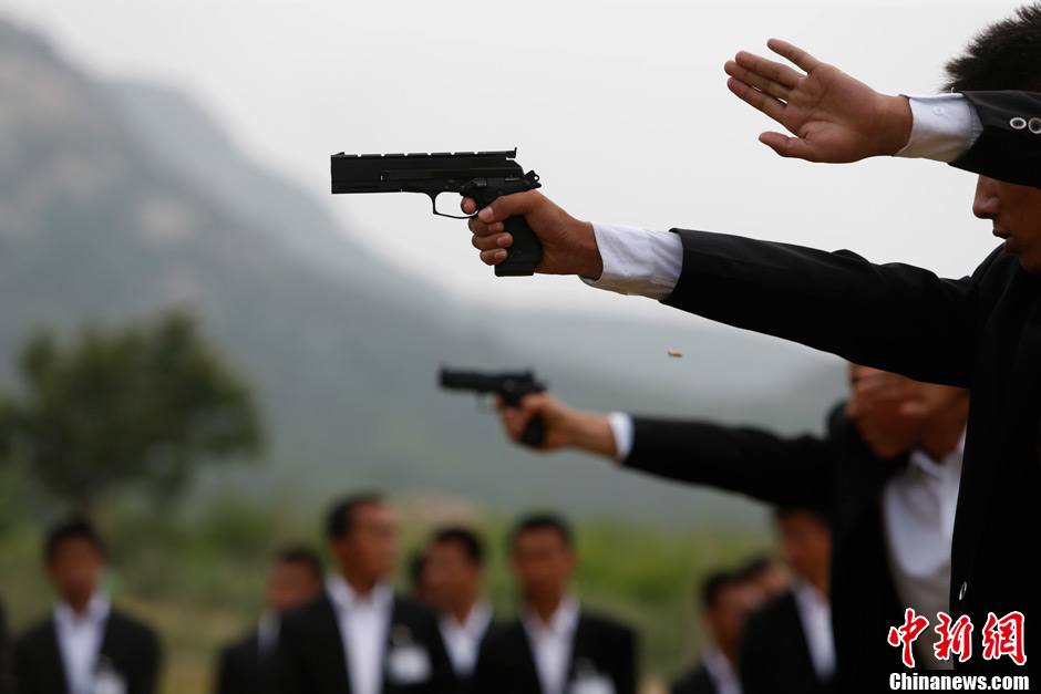 Trainees receive the tactical shooting training during a VIP security training course in Lianyungang, east China's Jiangsu province, June 30, 2013. (Chinanews/Liu Guanguan)