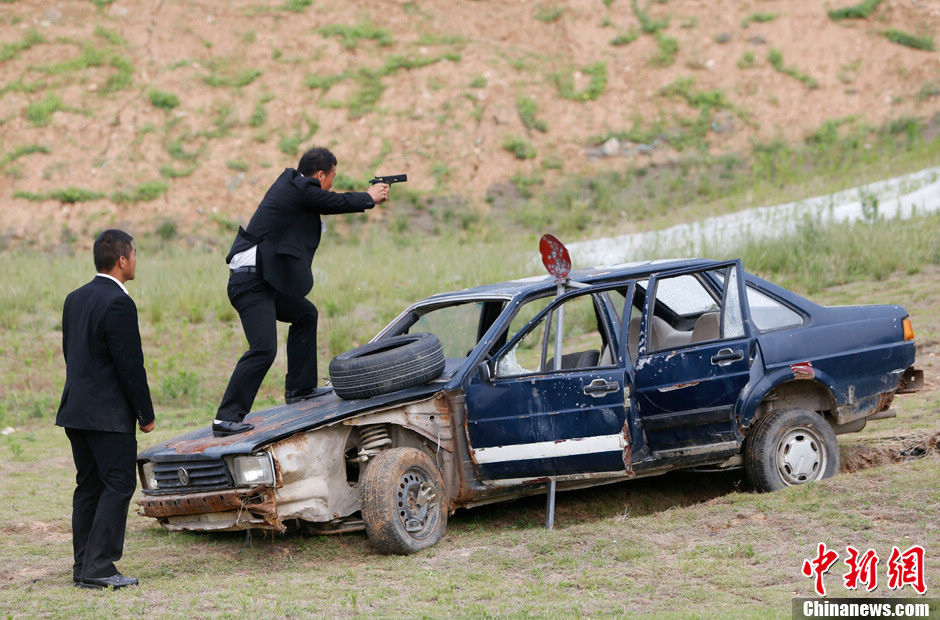 Trainees receive the tactical shooting training during a VIP security training course in Lianyungang, east China's Jiangsu province, June 30, 2013. (Chinanews/Liu Guanguan)