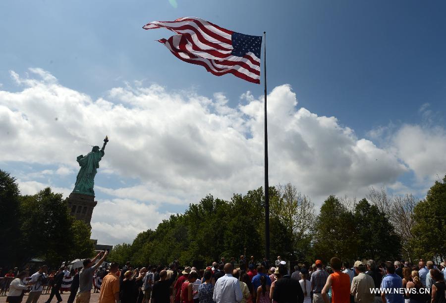 People attend reopening ceremony of the Statue of Liberty at Liberty Island in New York, the United States, on July 4, 2013, the U.S. Independence Day. The Statue of Liberty and Liberty Island reopened to the public on Thursday for the first time since Hurricane Sandy made landfall on Oct. 29, 2012. (Xinhua/Wang Lei)