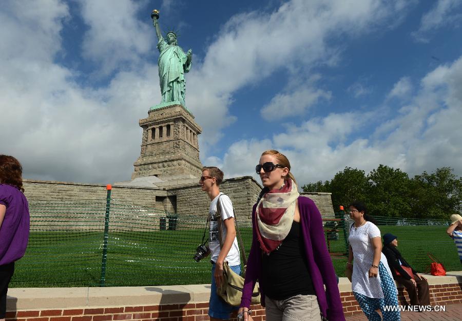 People visit the Statue of Liberty at Liberty Island in New York, the United States, on July 4, 2013, the U.S. Independence Day. The Statue of Liberty and Liberty Island reopened to the public on Thursday for the first time since Hurricane Sandy made landfall on Oct. 29, 2012. (Xinhua/Wang Lei)