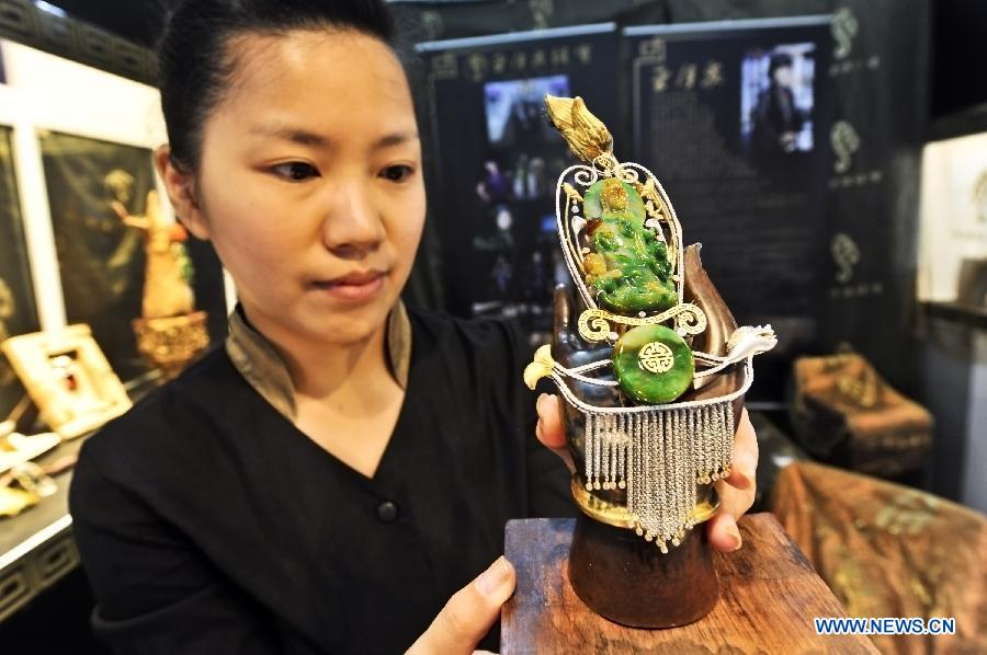 An exhibitor displays an ornament at the 2013 Beijing Summer Jewelry Show in Beijing, capital of China, July 4, 2013. (Xinhua/Wang Jingsheng)