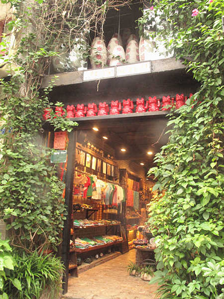 This photo taken on June 28th shows a garment shop in West Street in Yangshuo County of Guangxi Zhuang Autonomous Region. With a history of over 1,400 years, West Street is located in the center of Yangshuo County and is also called Foreigner's Street. Here, the bars, hotels, Internet cafes and painting shops' decoration style is mostly Chinese mixed with Western culture. (CnDG by Jiao Meng)