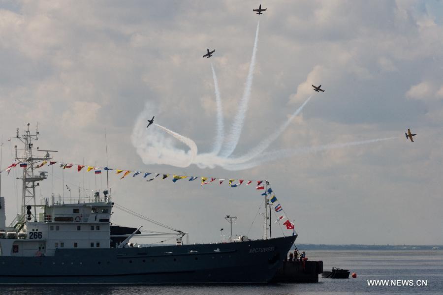 Aircrafts from Russia's MIG aerobatics team perform during the 6th International Maritime Defence Show in St.Petersburg, Russia, on July 4, 2013. The aerobatic teams will entertain crowds at the 6th International Maritime Defence Show to be held here from July 3-7. (Xinhua/Konkov)