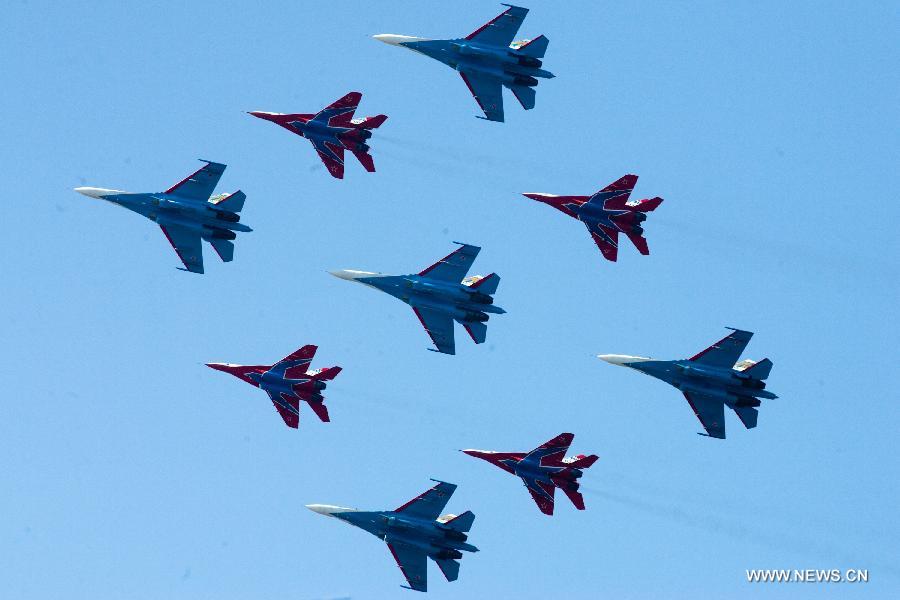 Aircrafts from aerobatics team "Russian Knights" and "Swifts" perform during the 6th International Maritime Defence Show in St.Petersburg, Russia, on July 4, 2013. The aerobatic teams will entertain crowds at the 6th International Maritime Defence Show to be held here from July 3-7. (Xinhua/Konkov)  