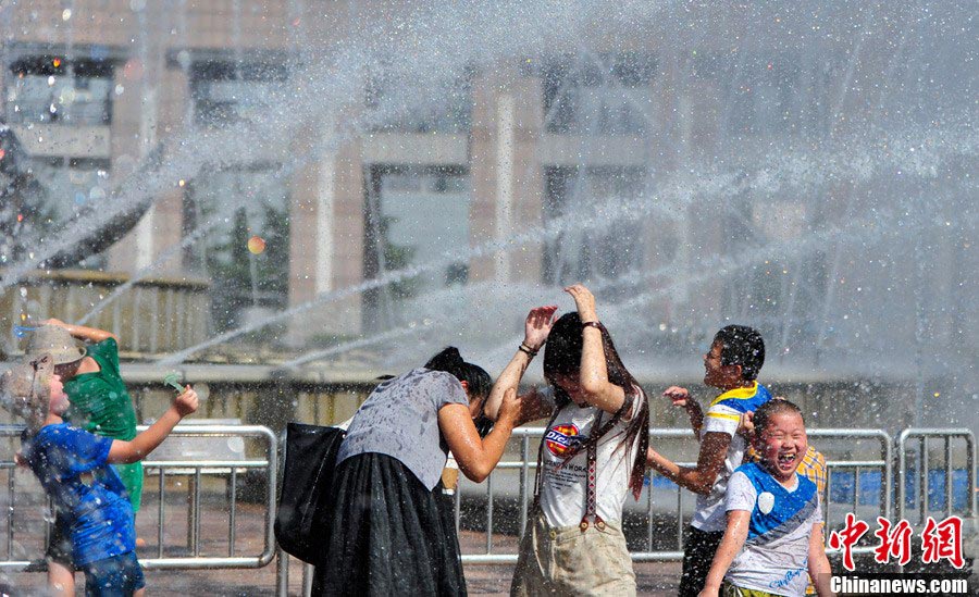 Citizens play with water beside a fountain in east China’s Jinan on July 2, 2013. Fountains have become the best choice for locals to beat summer heat. (CNS/Zhang Yong) 