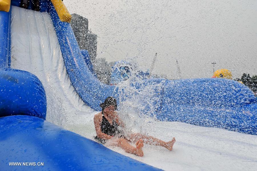 A woman plays on a water slide in the iRENA World, an aquatic amusement park in north China's Tianjin, June 29, 2013.(Xinhua/Zhai Jianlan) 