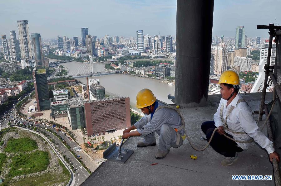 Construction workers reinforce bolts on the 30th floor of a high building in the heat in Ningbo City, east China's Zhejiang province, July 5, 2013. (Xinhua/Hu Xuejun) 