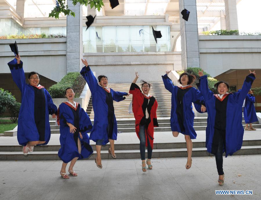 Postgraduates pose for photo in the Fourth Military Medical University in Xi'an, northwest China's Shaanxi Province, July 5, 2013. Altogether 245 Ph.D. students and 575 postgraduate students graduated from the university this year. (Xinhua/Ding Haitao)