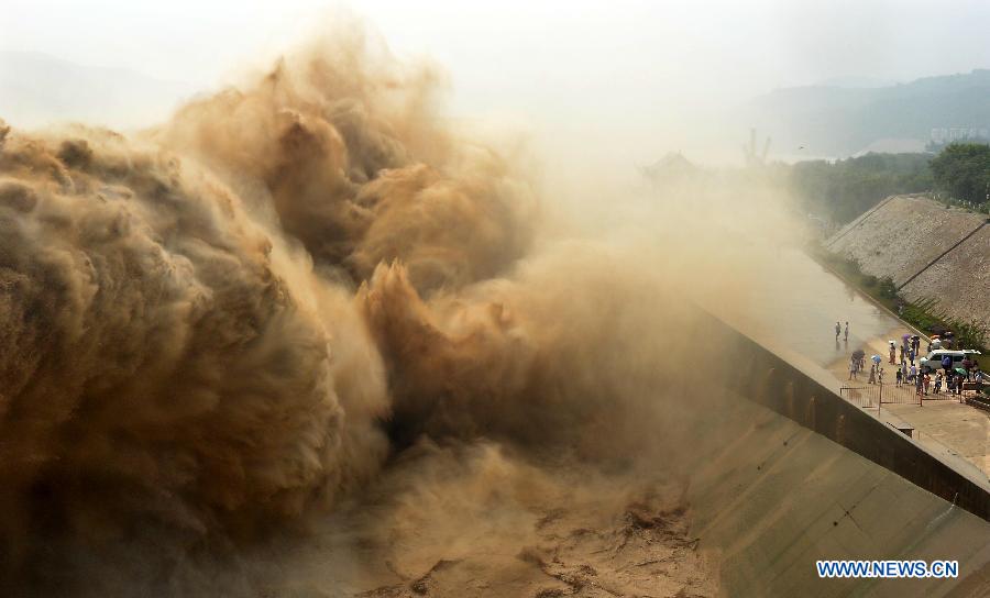 Tourists watch water gushing out from the Xiaolangdi Reservoir on the Yellow River during a sand-washing operation in Luoyang, central China's Henan Province, July 5, 2013. The on-going operation, conducted on Friday, works by discharging water at a volume of 2,600 cubic meters per second from the reservoir to clear up the sediment in the Yellow River , the country's second-longest waterway. Speeding currents would carry tons of sand into the sea. The Yellow River has been plagued by an increasing amount of mud and sand. Each year, the river bed rises as silt deposits build up, slowing the water flow in the lower reaches. (Xinhua/Wang Song) 