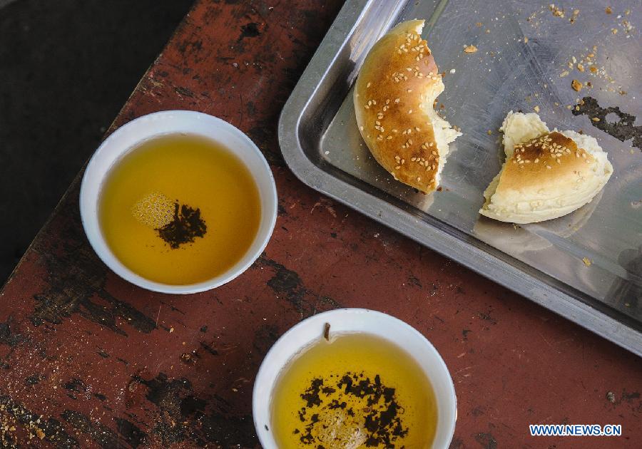 Photo taken on July 5, 2013 shows cups of tea and pieces of nang, a kind of baking food, at an old teahouse near the Id Kah Square in Kashgar, northwest China's Xinjiang Uygur Autonomous Region. With simple decoration, the teahouse is located at the second floor of an old-fishioned building and is favored by the old of Uygur ethnic group. They usually enjoy drinking tea and chatting after every morning prayer. (Xinhua/Shen Qiao)