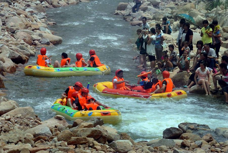 Tourists navigate a river during a river rafting festival at Jincun Township in Ruyang County, central China's Henan Province, July 6, 2013. (Xinhua/Wang Song)
