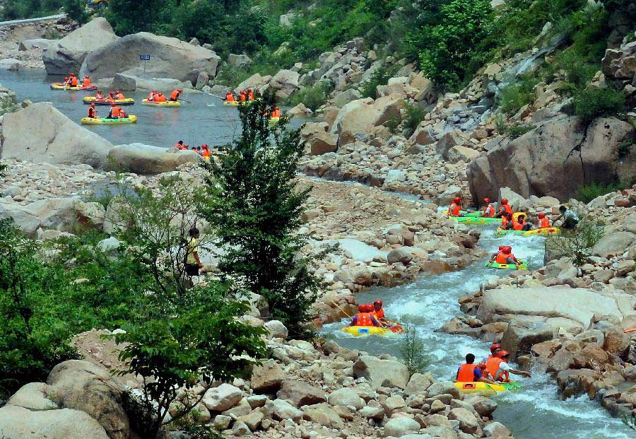 Tourists navigate a river during a river rafting festival at Jincun Township in Ruyang County, central China's Henan Province, July 6, 2013. (Xinhua/Wang Song)