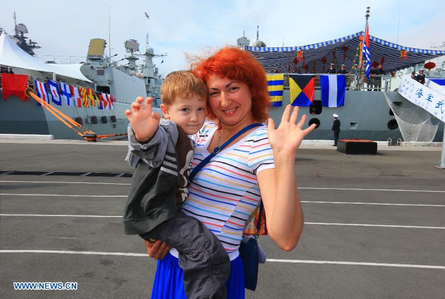 A Russian mother and her child visit the Chinese Navy Shijiazhuang guided-missile destroyer at the port in Vladivostok, Russia, July 6, 2013. The Chinese Navy Shijiazhuang guided-missile destroyer, which is participating in the "Joint Sea-2013" joint naval drills of China and Russia, opened to the public and Russian navy soldiers on Saturday. (Xinhua/Zha Chunming) 