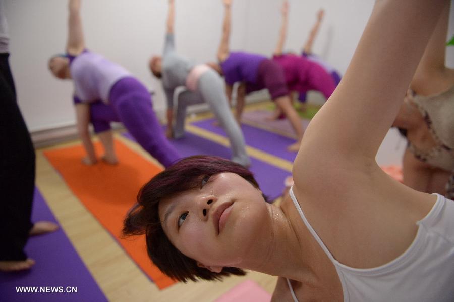 Participants practice hot yoga at a studio maintained at about 42 degrees Celsius in Nanchang, capital of east China's Jiangxi Province, July 5, 2013. (Xinhua/Zhou Mi) 