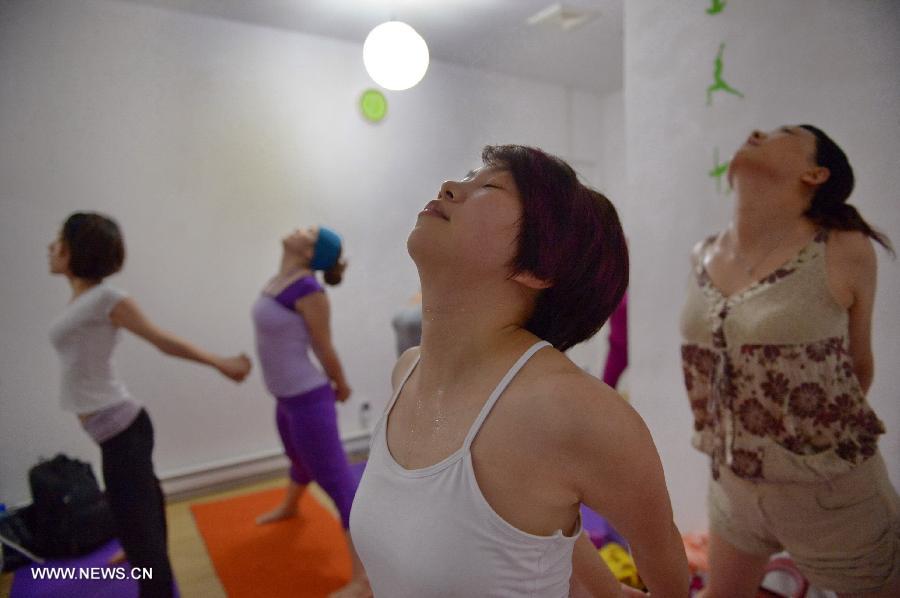 Participants practice hot yoga at a studio maintained at about 42 degrees Celsius in Nanchang, capital of east China's Jiangxi Province, July 5, 2013. (Xinhua/Zhou Mi) 