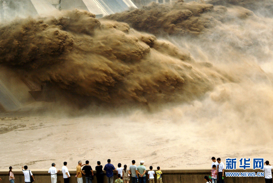 Tourists watch water gushing out from the Xiaolangdi Reservoir on the Yellow River during a sand-washing operation in Luoyang, central China's Henan Province, July 5, 2013.  (Xinhua/Lu Jianping)