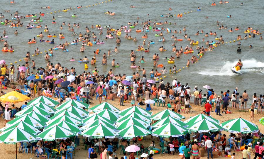 Tourists enjoy coolness at the Dashawan bathing beach in Lianyungang, east China's Jiangsu Province, July 6, 2013. The beach entered its tourism peak season with the rising temperature. (Xinhua/Wang Chun) 