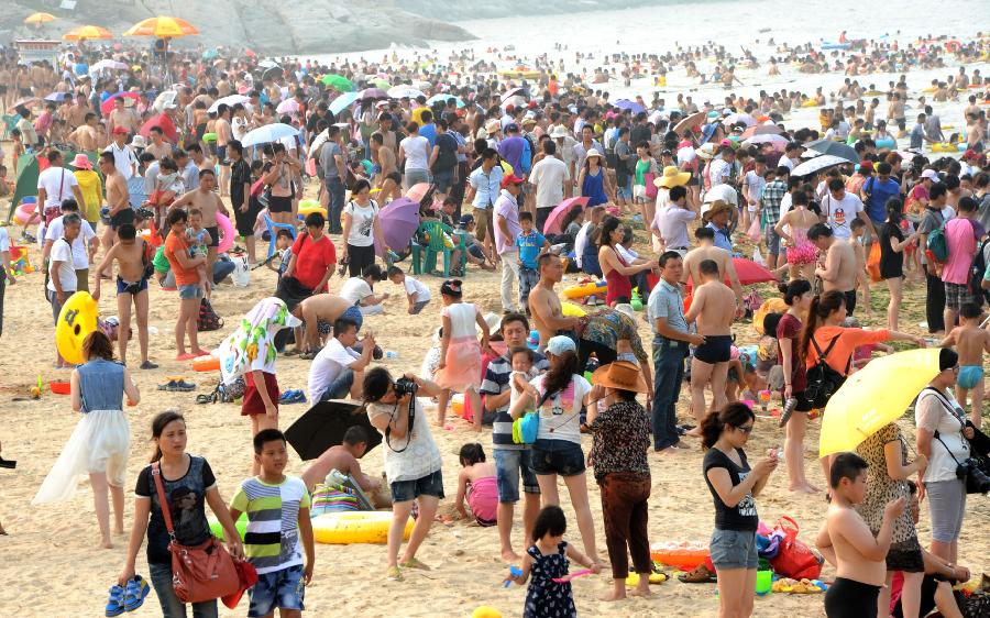 Tourists enjoy coolness at the Dashawan bathing beach in Lianyungang, east China's Jiangsu Province, July 6, 2013. The beach entered its tourism peak season with the rising temperature. (Xinhua/Wang Chun)