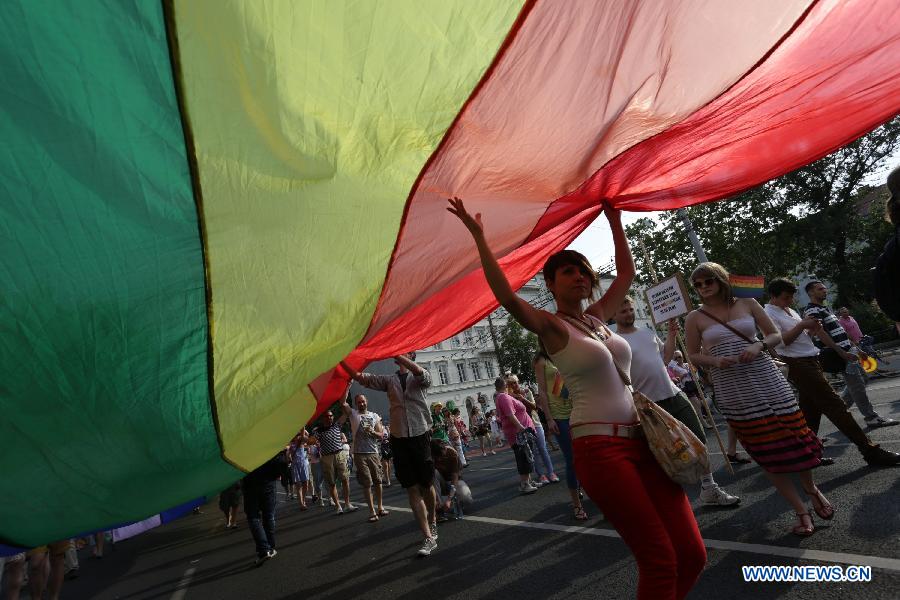 Participants carrying a rainbow flag, symbol of the LGBTQ movement, walk across the city during the Gay Pride Parade in Budapest, Hungary on July 6, 2013. (Xinhua/Attila Volgyi) 