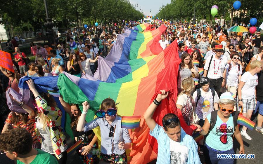 Participants carrying a rainbow flag, symbol of the LGBTQ movement, walk across the city during the Gay Pride Parade in Budapest, Hungary on July 6, 2013. (Xinhua/Attila Volgyi) 