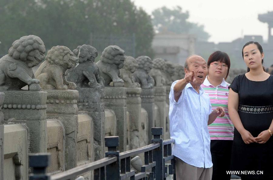 Zheng Fulai (L), a witness of the "July 7 Incident", recalls the past to visitors on the Lugou Bridge during a memorial event marking the 76th anniversary of "The July 7th Incident" in Beijing, capital of China, July 7, 2013. The "July 7 Incident" or the "Lugou Bridge Incident", marked the beginning of the War of Resistance by the Chinese people against Japanese aggression in 1937. (Xinhua/Gong Lei) 