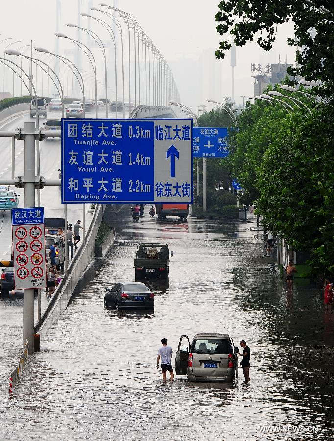 Cars stop on the flooded road in Wuchang District of Wuhan, capital of central China's Hubei Province, July 7, 2013. Wuhan was hit by the heaviest rainstorm in five years from Saturday to Sunday. The local meteorologic center has issued red alert for rainstorm for many times in sequence. (Xinhua/Xiao Yijiu) 