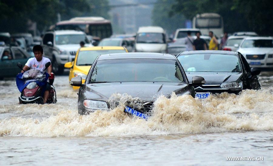 Cars drive on the flooded road in Wuhan, capital of central China's Hubei Province, July 7, 2013. Wuhan was hit by the heaviest rainstorm in five years from Saturday to Sunday. The local meteorologic center has issued red alert for rainstorm for many times in sequence. (Xinhua/Cheng Min) 