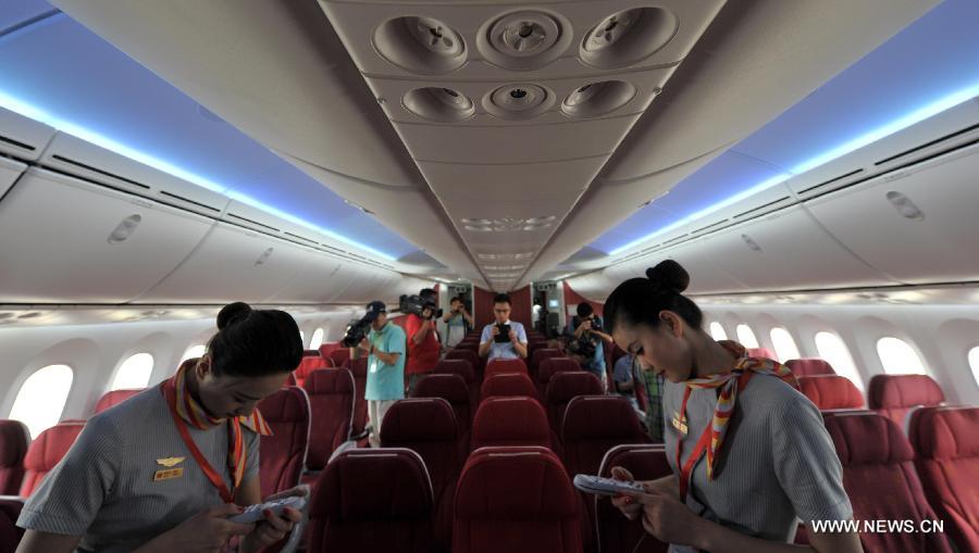 Crew members of the Haian Airlines are pictured in a Boeing 787 Dreamliner at the Haikou Meilan International Airport in Haikou, capital of south China's island of Hainan Province, July 7, 2013. Haian Airlines held a ceremony here to welcome the arrival of its first Boeing 787 Dreamliner. Mou Wei, vice president of Hainan Airlines, said on July 4 that the first 213-seat Dreamliner will serve the domestic route between Beijing and Haikou, capital of south China's Hainan Province, with 36 seats reserved for business class and 177 for economy. (Xinhua/Zhao Yingquan) 