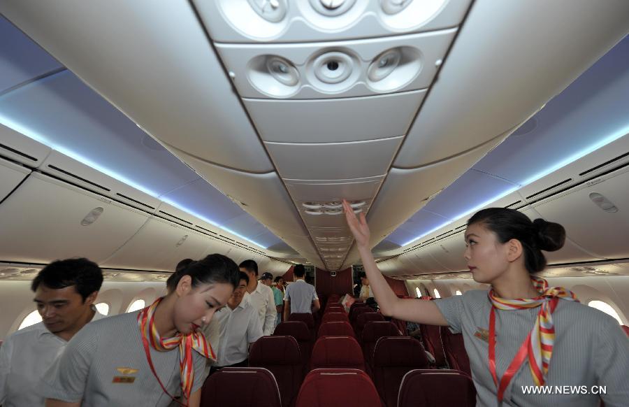 Crew members of the Haian Airlines are pictured in a Boeing 787 Dreamliner at the Haikou Meilan International Airport in Haikou, capital of south China's island of Hainan Province, July 7, 2013. Haian Airlines held a ceremony here to welcome the arrival of its first Boeing 787 Dreamliner. Mou Wei, vice president of Hainan Airlines, said on July 4 that the first 213-seat Dreamliner will serve the domestic route between Beijing and Haikou, capital of south China's Hainan Province, with 36 seats reserved for business class and 177 for economy. (Xinhua/Zhao Yingquan) 