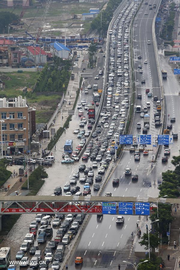 Cars jam on a partially flooded road in Wuhan, capital of central China's Hubei Province, July 7, 2013. Wuhan was hit by the heaviest rainstorm in five years from Saturday to Sunday. The local meteorologic center has issued red alerts for rainstorm for many times in sequence. (Xinhua)