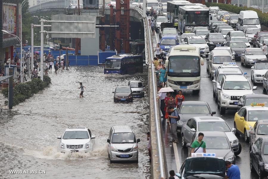 Cars move on a flooded road in Wuhan, capital of central China's Hubei Province, July 7, 2013. Wuhan was hit by the heaviest rainstorm in five years from Saturday to Sunday. The local meteorologic center has issued red alerts for rainstorm for many times in sequence. (Xinhua)
