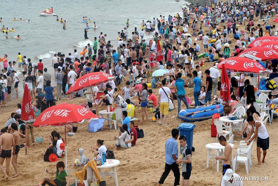 Tourists swarm a bathing beach in Qingdao, a coastal city of east China's Shandong Province, July 7, 2013. (Xinhua/Li Ziheng) 