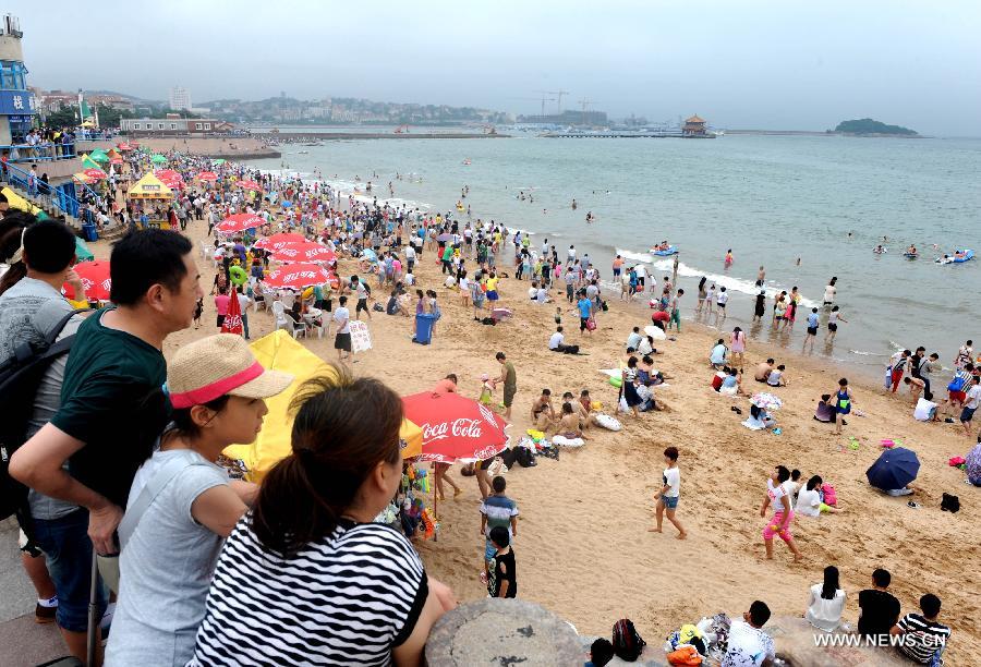Tourists swarm a bathing beach in Qingdao, a coastal city of east China's Shandong Province, July 7, 2013. (Xinhua/Li Ziheng) 