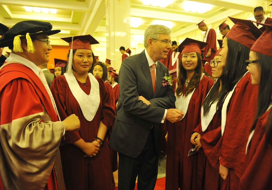 An honored guest communicates with graduates during the graduation ceremony held by Beijing Concord College of Sino-Canada for its senior high graduates in Beijing, capital of China, July 6, 2013. A total of 303 senior high students graduate from Beijing Concord College of Sino-Canada this year, among which ten were admitted by universities in China, other 293 were accepted by universities from abroad, according to the school authority. (Xinhua/Lu Peng)