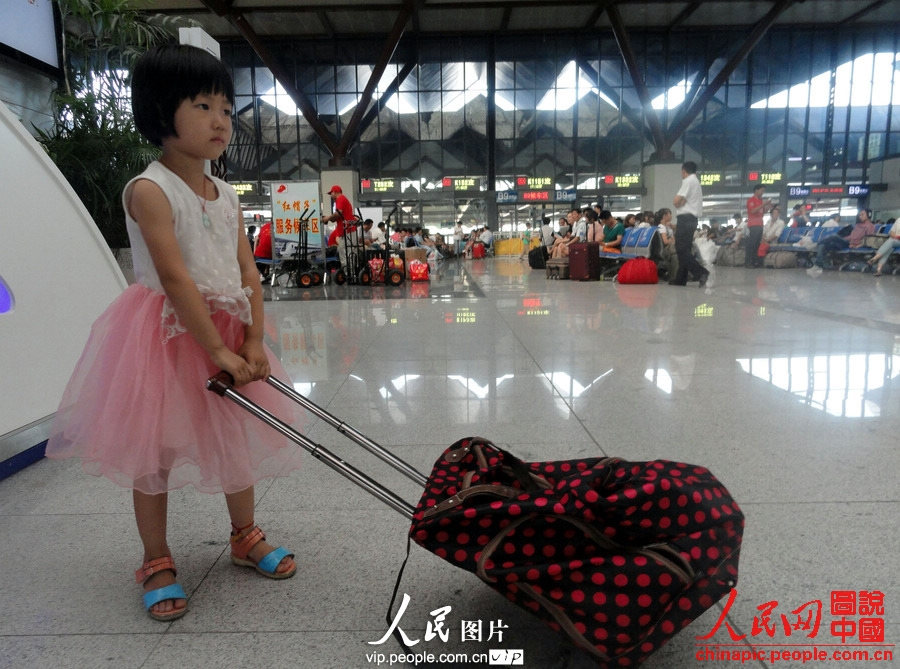 Child of migrant workers waits for the train at the Hefei Railway Station in east China's Anhui province, July 1, 2013. (photo/vip.people.com.cn)