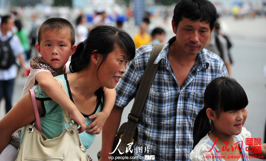 Two children accompanied by adults take the train to spend holidays with their parents working in cities at Fuyang Railway Station, east China's Anhui province, July 1, 2013. (photo/vip.people.com.cn)