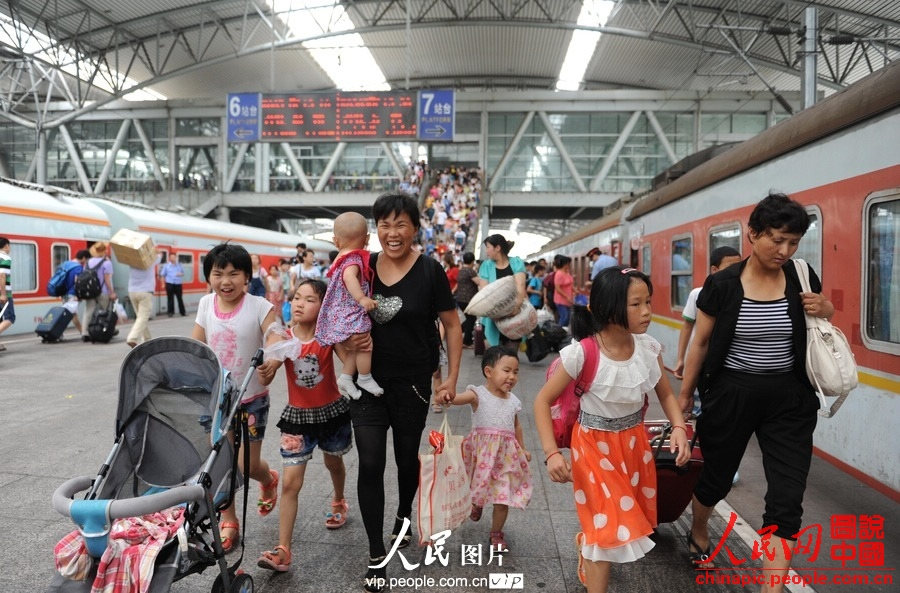 Several children accompanied by adults take the train to spend holidays with their parents working in cities at Fuyang Railway Station, east China's Anhui province, July 1, 2013. (photo/vip.people.com.cn)