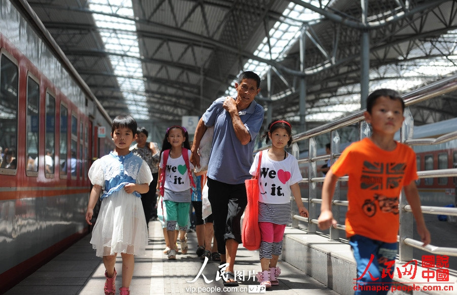 Several children accompanied by adults take the train to spend holidays with their parents working in cities at Fuyang Railway Station, east China's Anhui province, July 2, 2013. (photo/vip.people.com.cn)