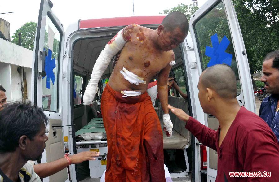 A Buddhist monk who was injured in an explosion gets off an ambulance in Bodhgaya, about 130 kilometers (80 miles) south of Patna, the capital of the eastern Indian state of Bihar, July 7, 2013. A series of small blasts hit three Buddhist temples in eastern India early Sunday, injuring at least two people, police said. (Xinhua)