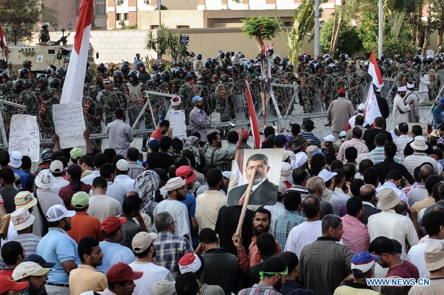 A Morsi supporter holds up a portrait of Egypt's ousted president Mohamed Morsi as he attends sit-in outside the Republican Guards headquarters in Nasr city, Cairo, Egypt, July 6, 2013. (Xinhua/Qin Haishi) 