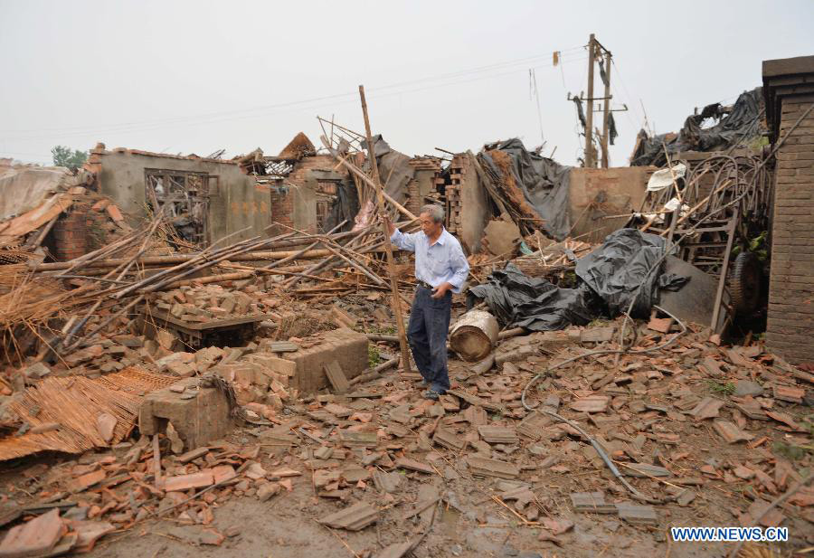 A man clears a house destroyed by a tornado at Nanfeng Village of Sanduo Township in Gaoyou City, east China's Jiangsu Province, July 7, 2013. A tornado hit Gaoyou around 4:40 p.m. Sunday, striking houses of more than 400 families and hurting over 50 people, seven of whom were severely wounded. (Xinhua/Wang Zhuo)