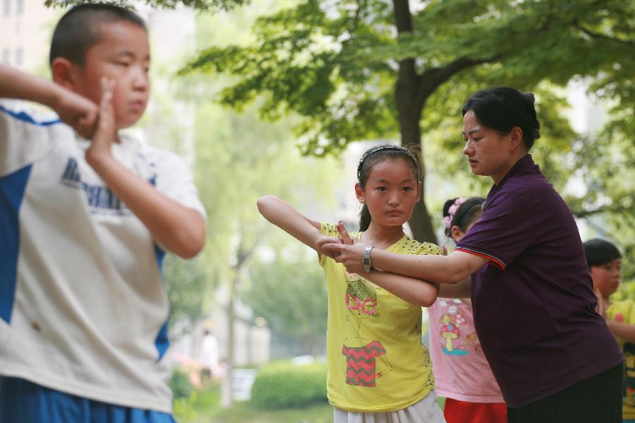 Children practise martial arts during their summer vacation in Nantong City, east China's Jiangsu Province, July 7, 2013. (Xinhua/Cui Genyuan)